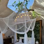 Chambre cocoon perchée, lit à baldaquin, verdure luxuriante et lumières intimistes en pleine nature. Auberge de la Tuilière