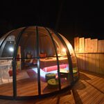 Dôme transparent sur terrasse bois, ambiance cosy et nature, pour une nuit insolite et intimiste. Auberge de la Tuilière