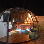 Dôme transparent cosy sur terrasse bois, décor chaleureux, intimité et confort uniques sous les étoiles. Auberge de la Tuilière