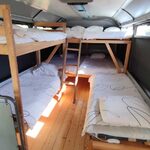 Bus aménagé bois, lits superposés et simples, linge graphique, lumière naturelle pour séjour insolite. Auberge de la Tuilière