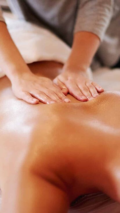 Moment détente au spa après une nuit insolite, allongé sur la table de massage, lumière tamisée. Auberge de la Tuilière