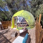 Dôme géodésique unique sur terrasse bois, mobilier en osier, nature paisible et hébergement insolite. Auberge de la Tuilière