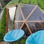Tipyramide nichée dans la nature, extérieur végétal, terrasse bois, séjour insolite et confortable. Auberge de la Tuilière