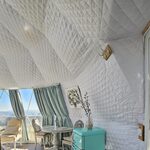 Dôme insolite lumineux, murs matelassés, grandes fenêtres triangulaires, déco cosy et mini-frigo vert menthe. Auberge de la Tuilière