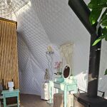 Cabane perchée cocooning, murs matelassés, poêle à bois ; déco fleurie et mobilier artisanal. Auberge de la Tuilière