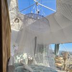 Tipyramide insolite : lit à baldaquin, lumière naturelle, coin salon cosy, vue sur la nature. Auberge de la Tuilière