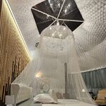 Cabane perchée moderne : lit blanc, ciel étoilé, bois et déco cosy pour une pause insolite et intime. Auberge de la Tuilière