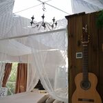 Chambre insolite lumineuse, lit à baldaquin, larges fenêtres, touches rustiques cabane perchée. Auberge de la Tuilière