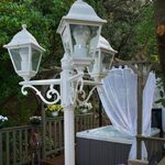 Lampadaire rétro, pergola voilée et spa, pour une pause unique au cœur d'un hébergement insolite. Auberge de la Tuilière
