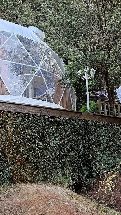 Dôme blanc sur terrasse bois, vue forêt ; expérience insolite, confort et intimité. Auberge de la Tuilière